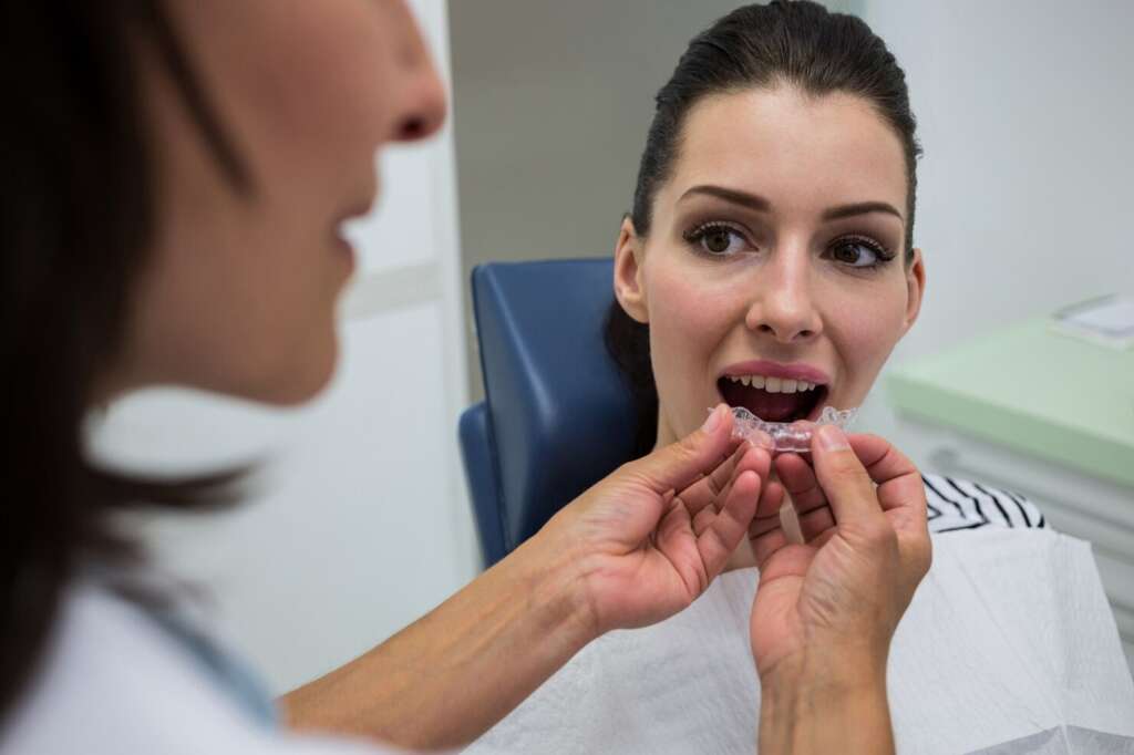 Patient receiving invisible braces with dentist discussing treatment time
